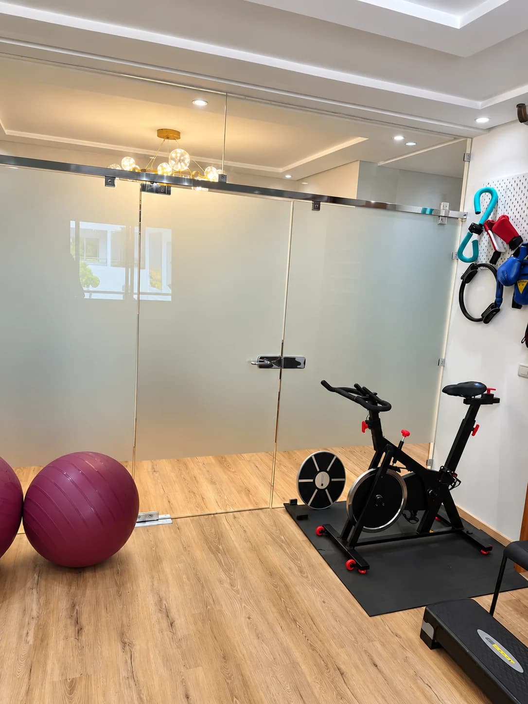 Vélo d’exercice, ballon violet et accessoires dans l’espace de mobilité du Cabinet Batal