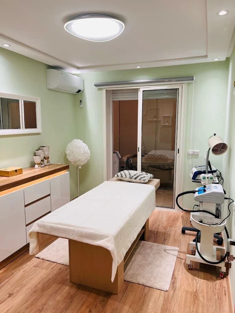 Salle de soins aux murs verts avec table de traitement et équipements